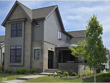 Charming two-story home with brick and siding, complemented by lush landscaping and a welcoming front porch at 17359 Wilkes Way, Westfield, IN 46074
