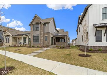 Beautiful home with a covered porch, modern siding, and professionally landscaped front yard and walkway at 17359 Wilkes Way, Westfield, IN 46074