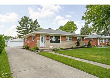 Charming single-story home with brick and stone facade, lovely landscaping, and a long concrete driveway at 2110 Allison Ave, Speedway, IN 46224