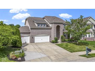 Charming brick home featuring a three-car garage and manicured front lawn at 543 Amersham Ct, Avon, IN 46123