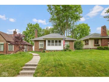 Charming brick home featuring a well-manicured lawn and inviting walkway at 5616 Winthrop Ave, Indianapolis, IN 46220