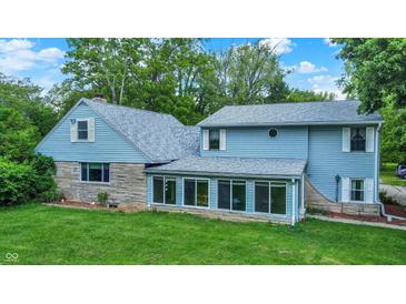 Charming home exterior featuring light blue siding, stone accents and lots of bright windows at 6430 E Southport Rd, Indianapolis, IN 46237
