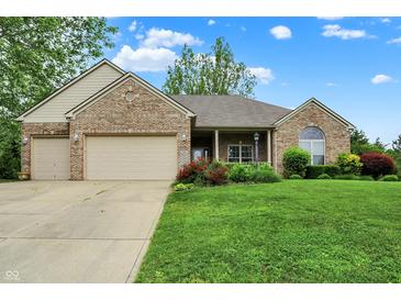 Charming single-story brick home featuring a well-manicured lawn and a two-car garage at 7310 Monaghan Ln, Indianapolis, IN 46217