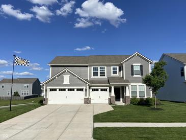 Charming two-story home with a three-car garage and a well-maintained lawn and beautiful blue skies at 8876 Boylan Pl, Pendleton, IN 46064