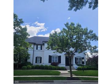 Charming white two-story home with black shutters, mature trees, and manicured landscaping at 12437 Meeting House Rd, Carmel, IN 46032