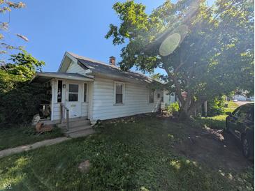 Charming single-story home featuring mature trees and a cozy front porch at 1433 N Denny St, Indianapolis, IN 46201