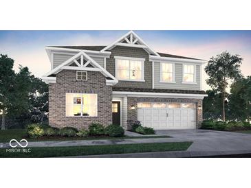 Charming two-story home featuring brick accents, a two-car garage, manicured lawn, and professionally designed landscaping at 19811 Moorpark Lndg, Noblesville, IN 46062