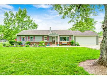 Charming ranch-style home with a well-manicured lawn and inviting curb appeal, set against a backdrop of mature trees at 318 S Routiers Ave, Indianapolis, IN 46219