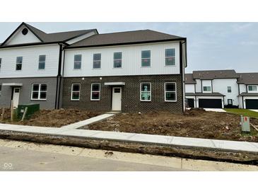 New two-story townhouse with brick and white siding and a walkway leading to the front door at 6248 Cascades Dr, Whitestown, IN 46075