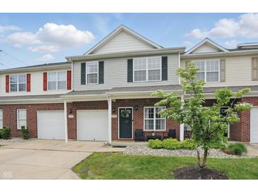 Inviting townhome with brick and siding exterior, attached garage, and well-maintained front yard landscaping at 9771 Blue Violet Dr, Noblesville, IN 46060