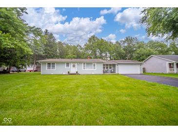 Charming single-story home features a well-manicured lawn, white trim, and an attached two car garage at 10097 N Balfer E Dr, Fortville, IN 46040
