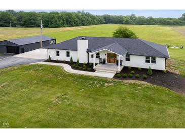 Stunning white brick home featuring a black roof, landscaped yard, and a detached garage at 10274 S 400 W, Pendleton, IN 46064