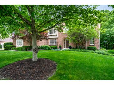 Well-manicured front yard with lush green lawn, mature trees, and a classic brick home at 14274 Matt St, Carmel, IN 46033