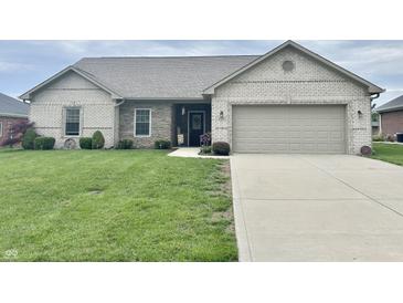 Charming single-story home featuring a two-car garage, manicured lawn and stone facade at 4920 E Daisy Ln, Mooresville, IN 46158