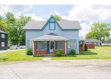 Charming two-story home with a covered front porch and a well-maintained lawn on a sunny day at 5 E Jefferson St, Maxwell, IN 46154