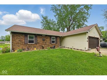 Charming brick home with a well-manicured lawn, decorative shutters, and an attached two-car garage at 9130 E 18Th St, Indianapolis, IN 46229