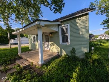 Charming cottage-style home with a covered porch and a well-maintained lawn at 9712 N Price St, Knightsville, IN 47857