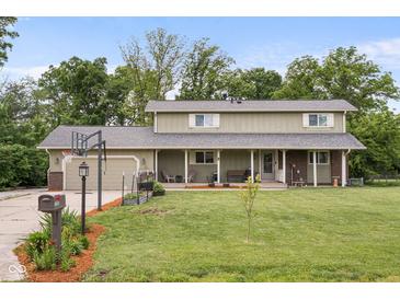 Charming two-story home with a covered front porch, a basketball hoop and a well maintained lawn at 12920 N Oakhaven Dr, Camby, IN 46113