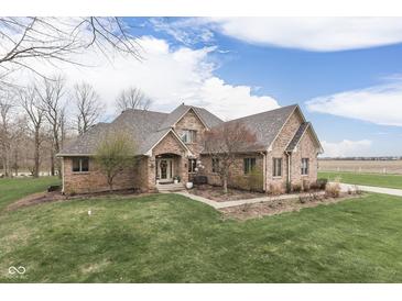 Charming brick home with a manicured lawn and mature trees, reflecting curb appeal at 1344 S Fox Paw Dr, New Palestine, IN 46163