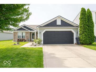 Charming single Gathering home with a well-manicured lawn, brick accents, and an attached two-car garage at 1414 Dowell St, Greenwood, IN 46143