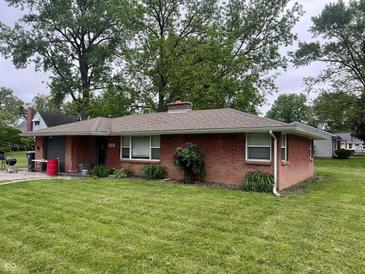 Charming brick ranch-style home with mature trees and a well-maintained front lawn at 2330 Ridgewood Dr, Anderson, IN 46012