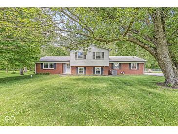 Charming brick home featuring a well-maintained lawn, mature trees, and classic architectural details at 2346 N State Road 39, Danville, IN 46122