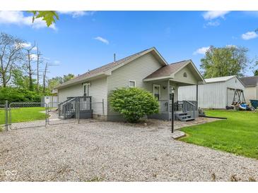 Charming home featuring a fenced yard, inviting entryway, and gravel driveway at 2414 N Blaine St, Muncie, IN 47303