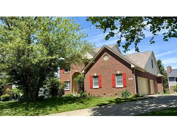 Charming brick home featuring a well-maintained lawn, red shutters and an attached garage at 404 Joseph Way, Carmel, IN 46032