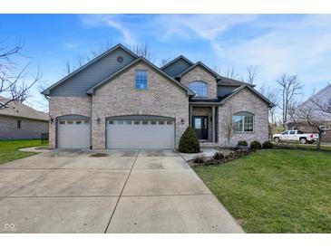 Two-story brick home with a three car garage and a well manicured lawn at 545 Walnut Woods Dr, Greenwood, IN 46142