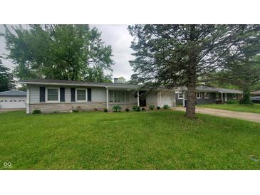 Charming single-story home with stone accents, light gray siding, well-kept landscaping, and an attached garage at 7435 E 50Th St, Indianapolis, IN 46226
