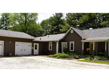 Charming home featuring a brown exterior, attached garage, and a landscaped front yard with gravel driveway at 8373 W State Road 47, Thorntown, IN 46071