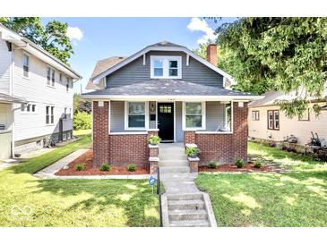 Charming two-story home features manicured lawn, brick accents, and inviting front porch at 920 E Tabor St, Indianapolis, IN 46203