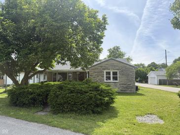 Charming single-story home with a stone accent wall, lush green lawn, and mature tree in the front yard at 222 Hanley St, Plainfield, IN 46168