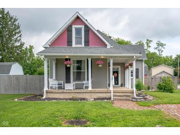 Charming home features a welcoming front porch with decorative columns and hanging flower baskets at 3360 Main St, Plainfield, IN 46168