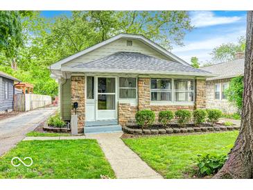 Charming home featuring stone accents, a well-manicured lawn, and inviting curb appeal at 5148 Crittenden Ave, Indianapolis, IN 46205