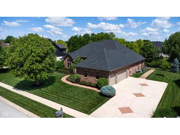 Beautiful aerial view of a brick home, with an attached garage and well-maintained yard, on a sunny day at 5350 Chico Grey Dr, Indianapolis, IN 46237