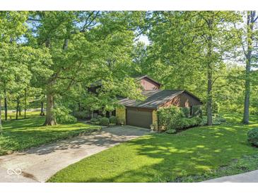Beautiful wooded lot with a two story house and attached garage in a suburban neighborhood at 577 Century Oaks Dr, Zionsville, IN 46077