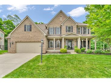 Stately two-story brick home with a well-manicured lawn and professionally landscaped front yard at 6168 Pine Bluff Dr, Avon, IN 46123