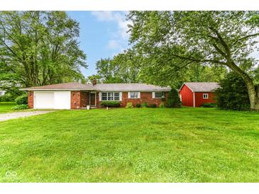 Charming brick ranch-style home featuring an attached garage and a spacious, well-manicured front yard at 7050 N County Road 650 E, Brownsburg, IN 46112
