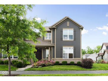 Charming two-story home with gray siding, trimmed windows, and landscaped front yard at 7152 Cherry Creek Blvd, Carmel, IN 46033