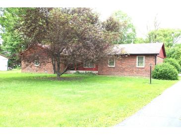 Charming brick home with large tree in the front yard and sidewalk leading to the street at 7931 Guion Rd, Indianapolis, IN 46268