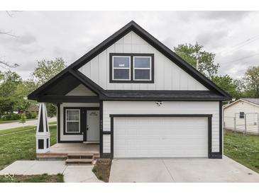 Charming two-story home with a white exterior, black trim, a garage, and a well-manicured front lawn at 9317 E 36Th Pl, Indianapolis, IN 46235