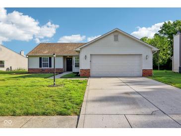 Charming single-story home featuring a well-manicured lawn and an attached two-car garage at 12250 Longstraw Dr, Indianapolis, IN 46236