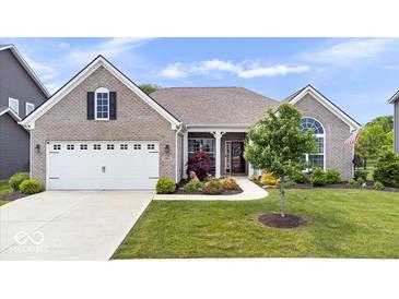 Charming brick home featuring a manicured lawn, two-car garage, and inviting front porch with beautiful landscaping at 1539 Hazy Falls Blvd, Westfield, IN 46074