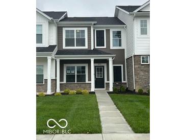 Charming two-story townhouse features a dark door, manicured lawn, and inviting facade at 19450 Northwest Dr, Westfield, IN 46074