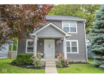 Charming two-story home with a well-maintained front yard and inviting entryway with chairs and decor at 2235 N Kenwood Ave, Indianapolis, IN 46208