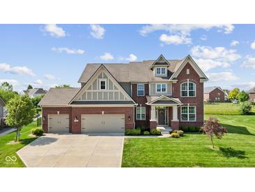 Beautiful two-story brick home featuring a three-car garage and manicured lawn at 2447 Stonehaven Dr, Avon, IN 46123