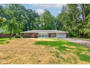 Charming brick ranch home featuring an attached garage and a tree-lined front yard at 3339 Devereaux Dr, Indianapolis, IN 46228