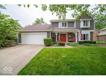 Charming two-story home with a red front door, landscaped yard, and an attached two-car garage at 506 Deerberry Dr, Noblesville, IN 46062