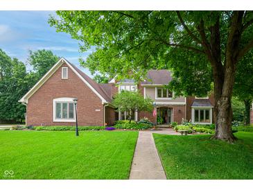 Traditional brick home with a lush front yard and mature trees, offering classic curb appeal at 5073 St Charles Pl, Carmel, IN 46033